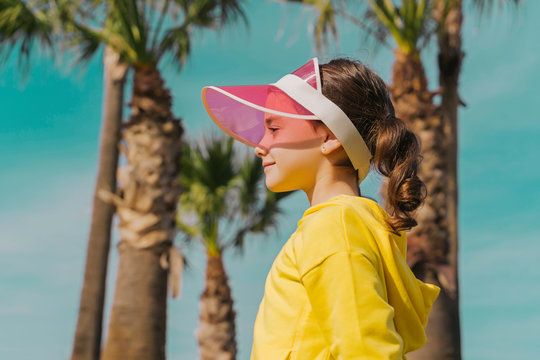 Smiling girl wearing sun visor standing outdoors