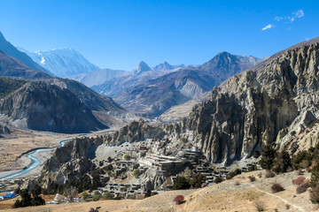 A temple complex in Manang Annapurna Circuit Trek, Nepal. Stupa in front of other buildings. Temple built on a rocky mountain hills. Sacred place for many Buddhist tourists. Dry land. Clear sky.