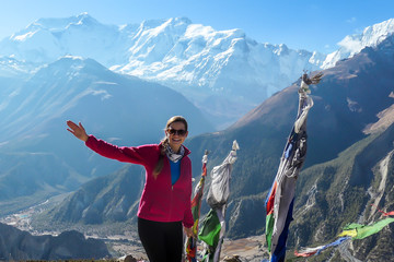 A woman in hiking outfit standing on a barren pathway along Annapurna Circuit Trek. There are few...
