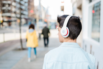 teenager walking down the street with a headset