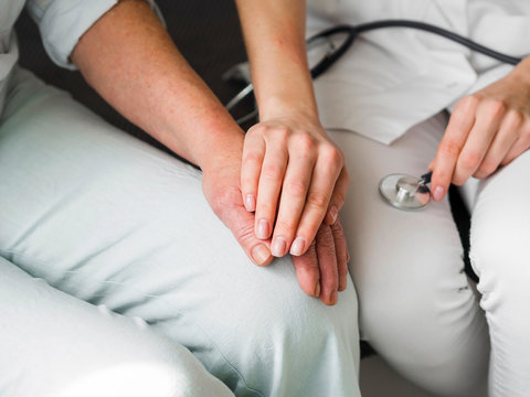 Close-up doctor with patient holding hands - Powered by Adobe