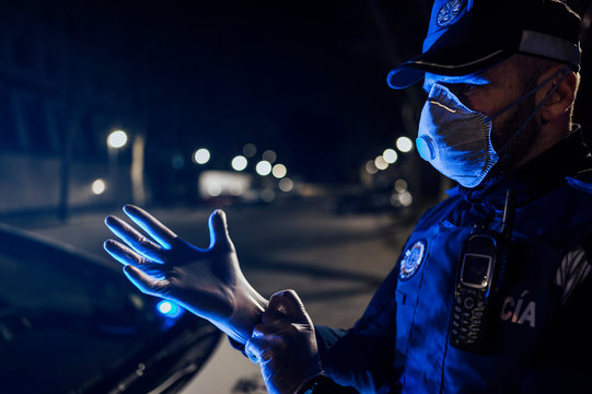 Portrait of policeman wearing mask and protective gloveat night