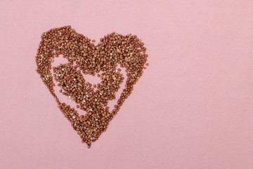 buckwheat is in the shape of a heart  on a pink background