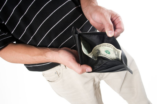 A person holds open a wallet with only one dollar in it in order to depict poverty and/or economic crisis.