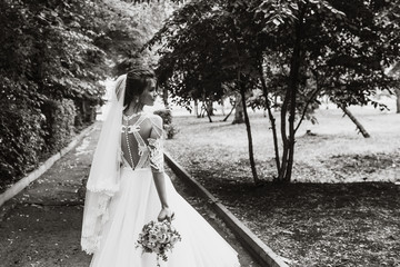 portrait of a bride with flowers in a beautiful full-length wedding dress, young brunette, tender photo wedding portrait