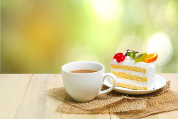 Slice cake with coffee cup on wood , green blur background