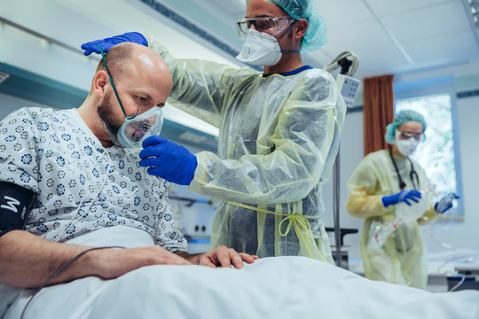 Doctor giving artificial respiration to patient in emergency care unit of a hospital