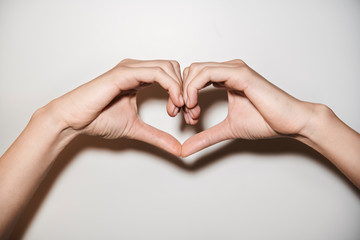 Close up of woman's hands making heart shape