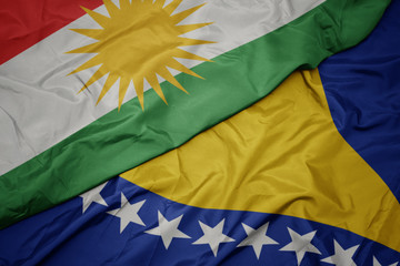 waving colorful flag of bosnia and herzegovina and national flag of kurdistan.