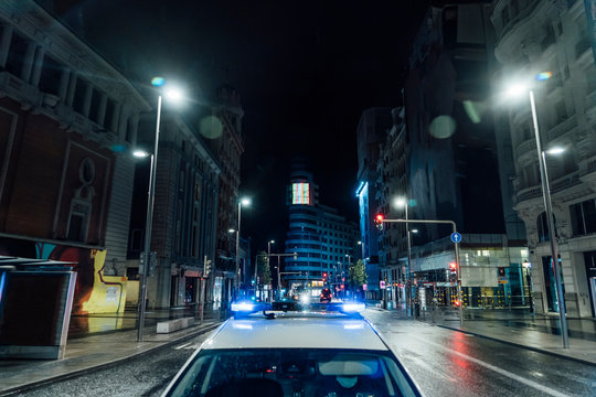 Spain, Madrid, Roof of police car driving along city street at night