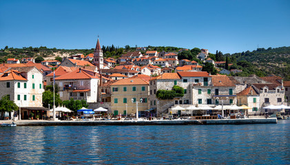 Panorama, coastline and red roofs of village Postira on island Brac in Croatia