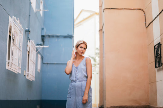 Portrait of young woman wearing light blue overall in the city