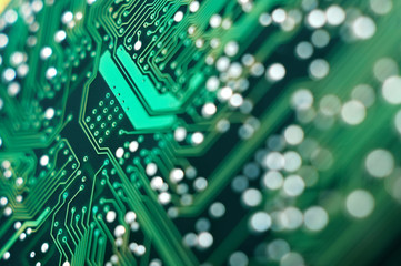 A macro detailed image of a small green microchip circuit board.