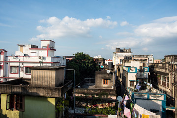 Beautiful blue sky with white clouds above the buildings in an Indian city. Indian cityscape.