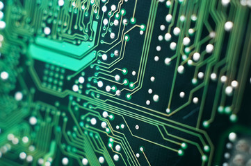 A macro detailed image of a small green microchip circuit board.