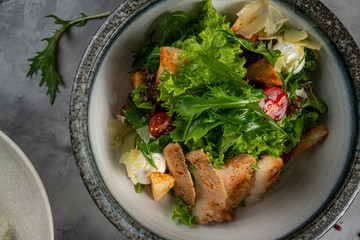 Fresh salad with chicken breast, arugula and tomato on a plate