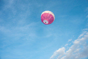  A colorful lantern/balloon is flying in the blue sky with white clouds in the afternoon of Diwali. Indian festival