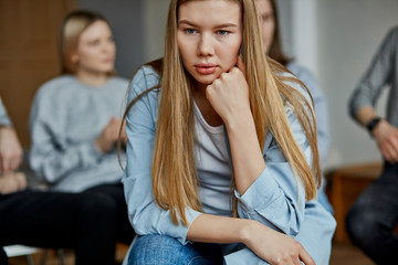 sad young girl caucasian female sit at fight meeting, solve alcoholism addiction together with such addicted people