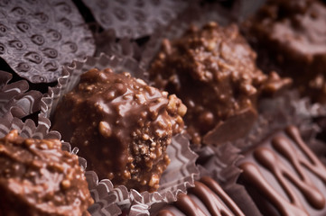 Mixed luxury dark and milk chocolate truffles. Assorted delicious handmade chocolate pralines in a row. Full frame background. Studio shot. Close-up