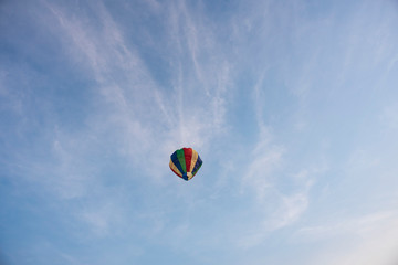  A colorful lantern/balloon is flying in the blue sky with white clouds in the afternoon of Diwali. Indian festival