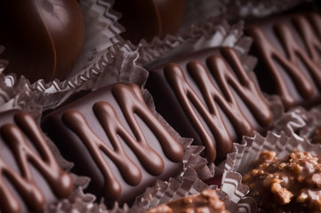 Mixed luxury dark and milk chocolate truffles. Assorted delicious handmade chocolate pralines in a row. Full frame background. Studio shot. Close-up