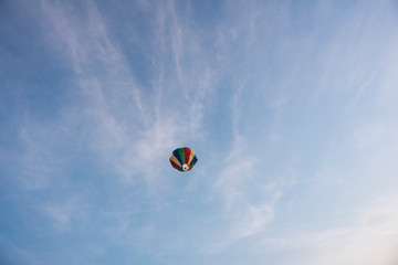  A colorful lantern/balloon is flying in the blue sky with white clouds in the afternoon of Diwali. Indian festival