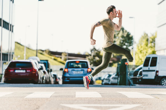 Disabled athlete with leg prosthesis exercising in the city on a zebra crossing