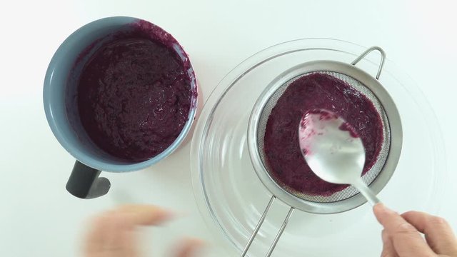 Time lapse. With spoon and sieve, preparing jam and sifting jaboticaba or jaboticaba. Organic red fruit rich in vitamins.