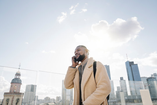 Stylish man on the phone on observation terrace with skycraper view, Frankfurt, Germany