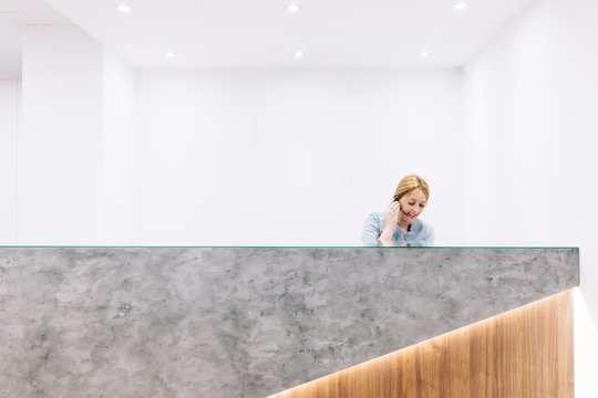 Receptionist with headset at reception desk of a medical practice