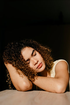 Portrait of attractive young woman leaning on a table in sunlight