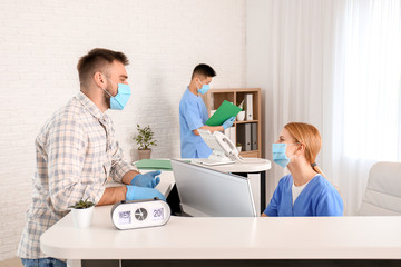 Female receptionist working with patient in clinic