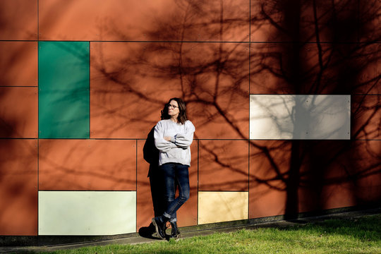 Woman leaning on multicolored wall