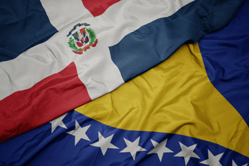 waving colorful flag of bosnia and herzegovina and national flag of dominican republic.