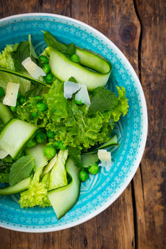 Plate of salad with green peas, mint, cucumber, Parmesan cheese and Lollo Bionda lettuce