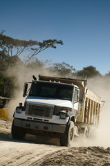 An industrial dump truck transporting dirt in a construction site.