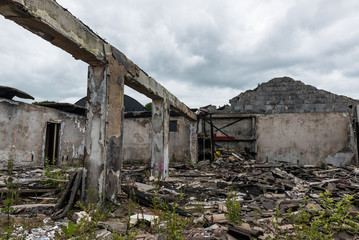 Abandoned burned out building with collapsed roof,  cloudy skies background
