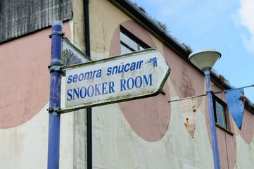 Bilingual sign in Irish Gaelic and English to the snooker room of an abandoned hotel