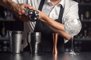 Close up of squeezing citrus juice into drink shaker. Stage of cocktail preparation.