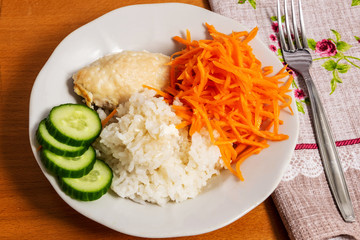 A white plate topped with meat and vegetables
