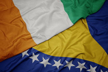 waving colorful flag of bosnia and herzegovina and national flag of cote divoire.