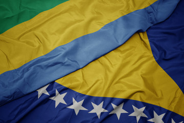 waving colorful flag of bosnia and herzegovina and national flag of gabon.