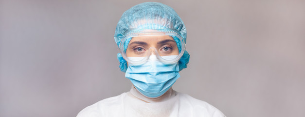 Doctor virologist in medical uniform and goggles, close-up portrait, seriously looking at the camera. widescreen high-quality image. copy space. blank space for text or logo