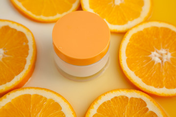 Naklejka na ściany i meble Cosmetic jar with natural energy vitamin skin care. Cosmetic cream on an orange background.