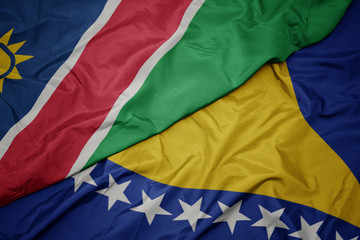 waving colorful flag of bosnia and herzegovina and national flag of namibia.