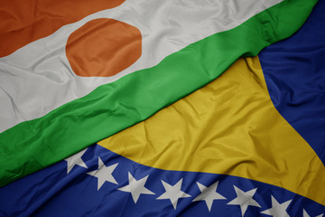 waving colorful flag of bosnia and herzegovina and national flag of niger.