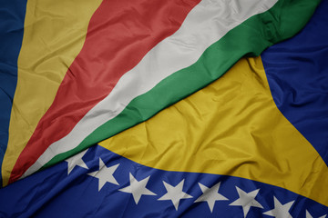 waving colorful flag of bosnia and herzegovina and national flag of seychelles.