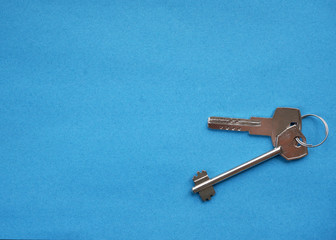 House keys on a blue background close-up.