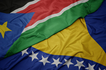 waving colorful flag of bosnia and herzegovina and national flag of south sudan.