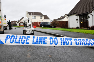 Police tape closes off a residential street as army ATOs use a robot to make safe a suspicious device - obrazy, fototapety, plakaty